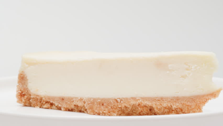 Classic dessert cheesecake on plate close-up. Cheesecake is a dessert made with a soft fresh cheese , typically cottage cheese, cream cheese, quark or ricotta, eggs, and sugar. It may have a crust or