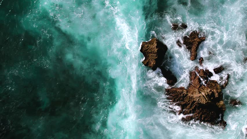 Top down video of waves crashing in ocean near Uluwatu temple in Bali Indonesia