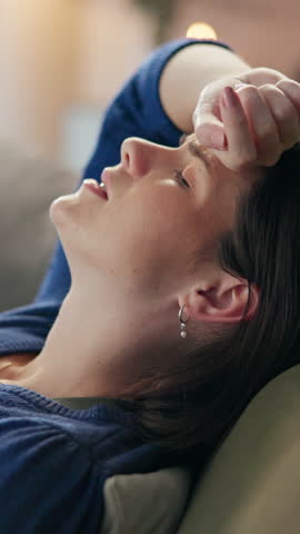 Home, tired and woman with headache, burnout and fatigue with pain in living room. Apartment, person and girl on couch, migraine and anxiety with mental health, depression and stress in lounge
