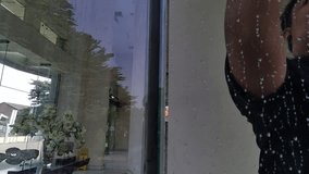 A man cleaning a window at home using a mop. Professional window cleaning service for homes and offices. Slow-motion footage. A worker washes a glass window in a modern room. - Powered by Shutterstock - Get 15% off with code: PIKWIZARD15