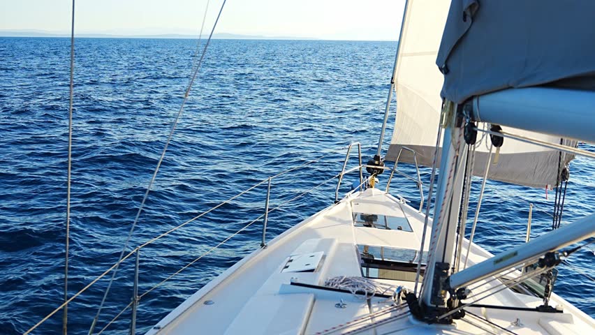 Yacht sailing in an open sea. Close-up view of the deck, mast and sails. Yachting concept. High quality 4k footage