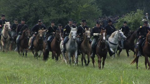 CHICKAMAUGA,GEORGIA - OCTOBER 2008 - Large-scale, epic Civil War anniversary reenactment -- in the middle of battle.  Union Cavalry gallops into battle as a column as battle rages in the distance.