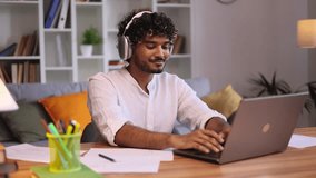 Portrait of handsome young man freelancer with headphones listening music while having work typing browsing scrolling products in internet online store on laptop computer at office workplace - Powered by Shutterstock - Get 15% off with code: PIKWIZARD15