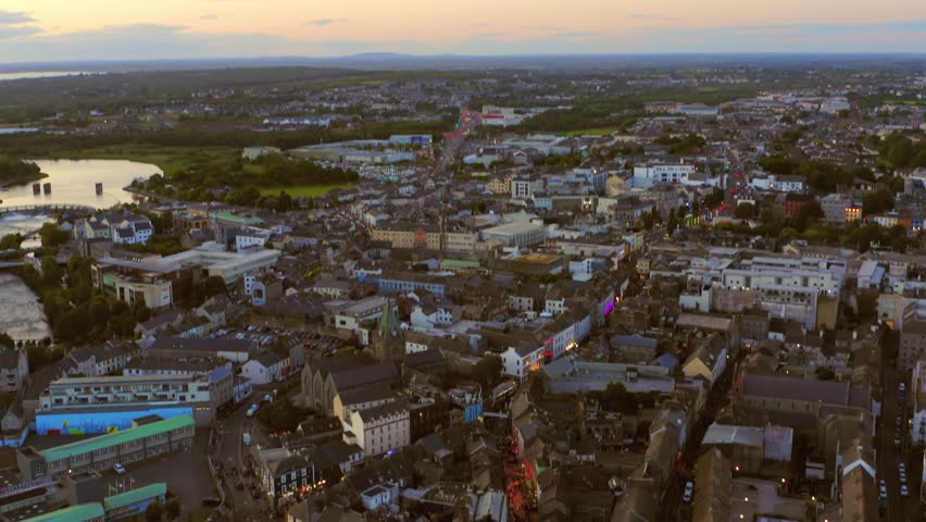 Aerial tilt-down view of Galway city center at night during the Arts Festival, showcasing illuminated streets and festival activities