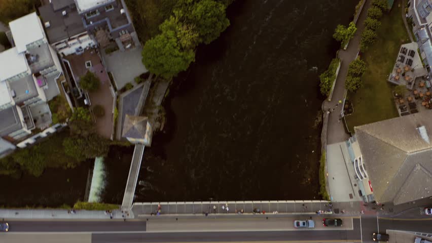 Fast shot following the River Corrib at night during the Galway Arts Festival. Aerial top-down view.
