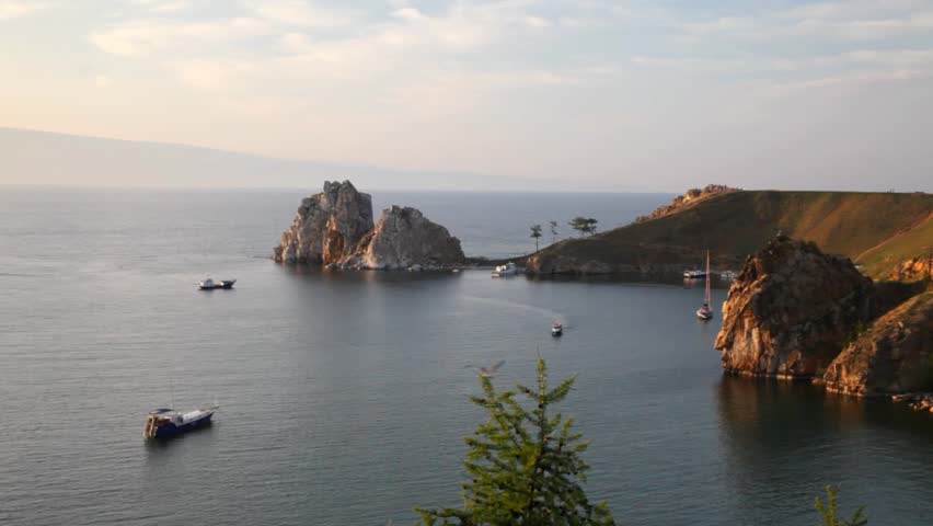 Video of Baikal Lake. Olkhon Island on summer evening. View of famous Shamanka Rock and rocky shore of Khuzhir village at sunset. Natural background. Scenic summer landscape. Travel and outdoors 
