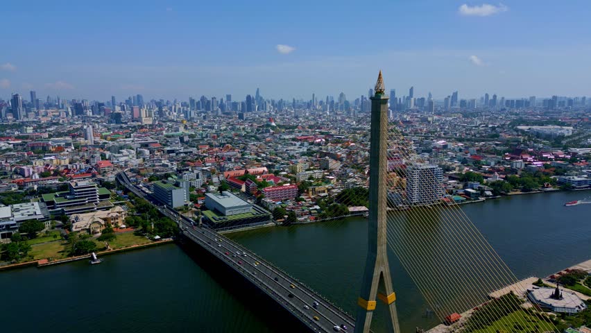 Bangkok, Thailand, Southeast Asia - An Impressive View of the Rama VIII Bridge, With Vehicles Crossing it Over the Chao Phraya River and the City Panorama in the Background - Drone Flying Forward