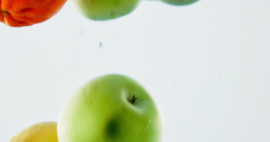 Fruit, water and mix with vitamin c for fresh produce, hydration or wash on a white background. Closeup of juicy, natural organic food or citric acid in wet splash for healthy diet or nutrition