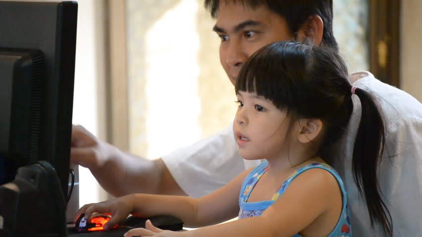 asian father teach cute daughter use computer