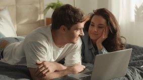 Man woman couple laptop networking technology web browsing internet guy girl watching movie date bedroom bed home female male talk smile laugh romance relax love electronic device chatting sweetheart - Powered by Shutterstock - Get 15% off with code: PIKWIZARD15