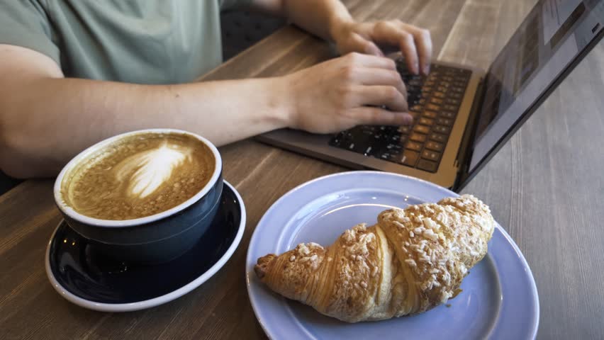 Young Man Enthusiastically Working Within a Cozy Cafe Environment, close-up