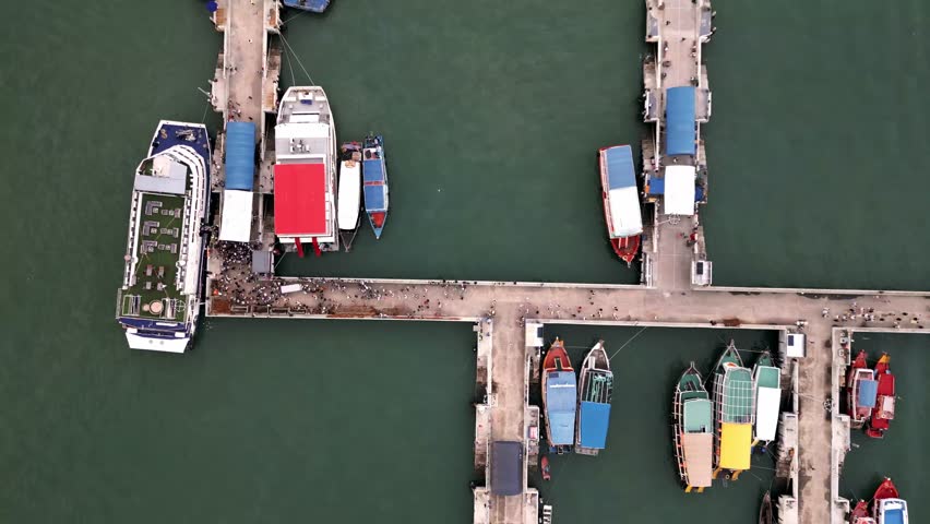 aerial top down of pier in pattaya with tourist boarding the boat for visiting Ko Lan island gulf of Thailand zoom in