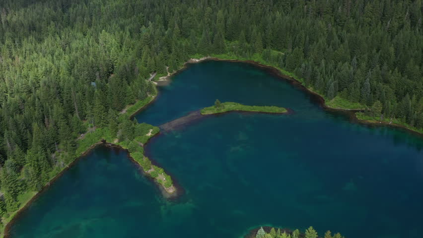 Turquoise Lake Nestled in a Mountain Valley Aerial Orbit Drone View