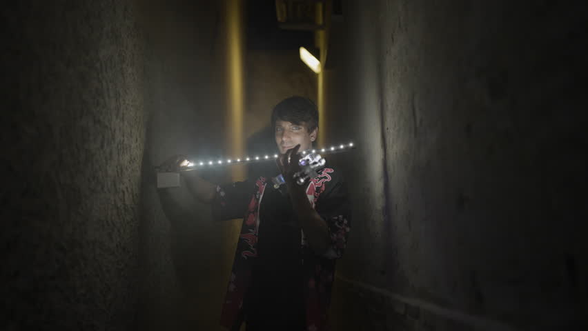 Man plays glowing violin at night with smoke