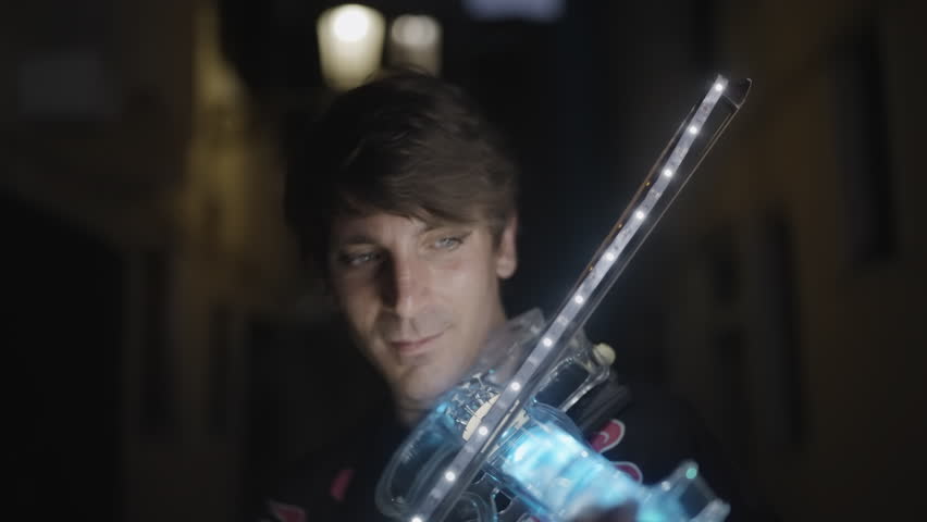 Leaves fall on man playing luminous violin