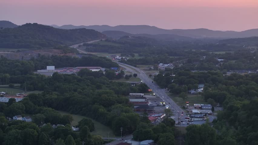 Aerial view of highway going through small town in rural America at sunset