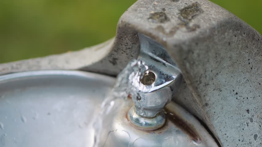 Water flowing from an old-fashioned public drinking fountain in 4k slow motion 120fps