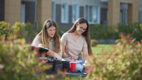 Online education on grass in park. students study online via video link.group of students make notes in a notebook. online communication with teacher via laptop. video lesson in park. online education - Powered by Shutterstock - Get 15% off with code: PIKWIZARD15