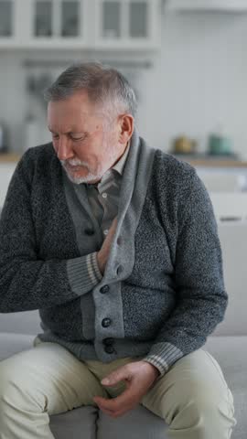 Heart attack of aged male person, portrait of old man feeling sharp pain in upper quadrant, vertical video. Sick senior man grabbing chest, screaming loudly, dangerous health conditions, healthcare