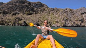 Young man in kayak paddling through emerald waters in Big Lagoon El Nido Philippines. Adventure, Fun, Healthy Lifestyle, Water Recreation, Enjoying Nature - Powered by Shutterstock - Get 15% off with code: PIKWIZARD15