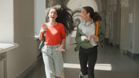 Two happy active running young students girls smiling laugh females women friends Hispanic Latina multiracial ladies run hurry rush to course lecture class in academy college university late studying - Powered by Shutterstock - Get 15% off with code: PIKWIZARD15