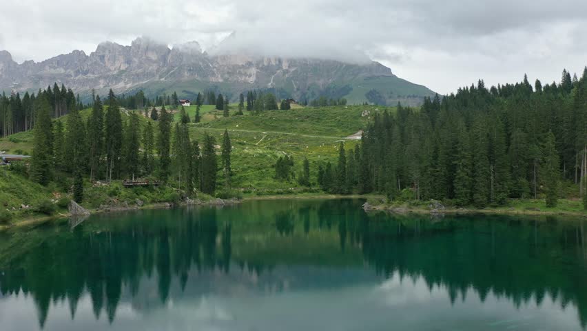 Aerial view of the Castle on the mountain lake Karersee and the surrounding forest and Dolomite mountains in South Tyrol, Italy