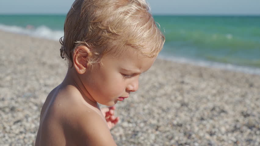 Little boy playing on the beach in summer. Child face close-up by the sea. Yevpatoriya, Crimea, Russia 2024
