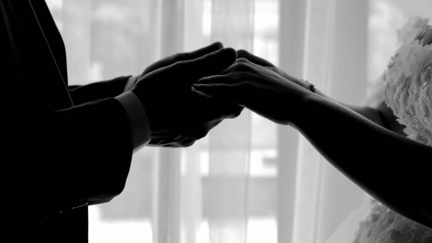 Silhouette of couple holding hands In a quiet room. A black and white silhouette of a couple holding hands.