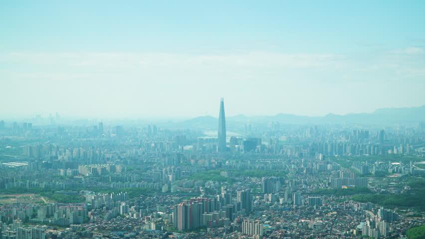 Zooming out From Jamsil District Lotte Worl Tower Revealing Seoul City Skyline on Summer Day. View from Namhansan Mountain