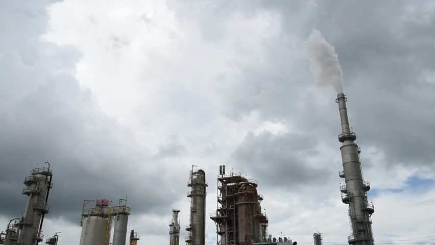 Large oil cracking refinery complex with tankage, distillation unit, steam, power, water-treatment plant, gas flare or flare stack clouds of exhaust fumes in San Antonio, Texas, gasoline industry. USA