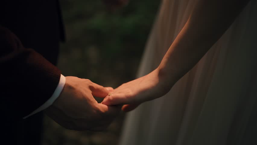 Couple holding hands in the warm light of the sun, serene scene, close up slow motion