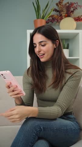Vertical woman celebrating that she has won a sports bet while checking the result on a smartphone app. Female betting at an online casino with a cellphone. excited lady watching the lottery prize