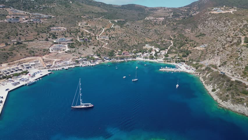 The drone aerial footage of Agios Nikolaos island, Agios Nikolaos Harbour and beach, Zakynthos, Greece.