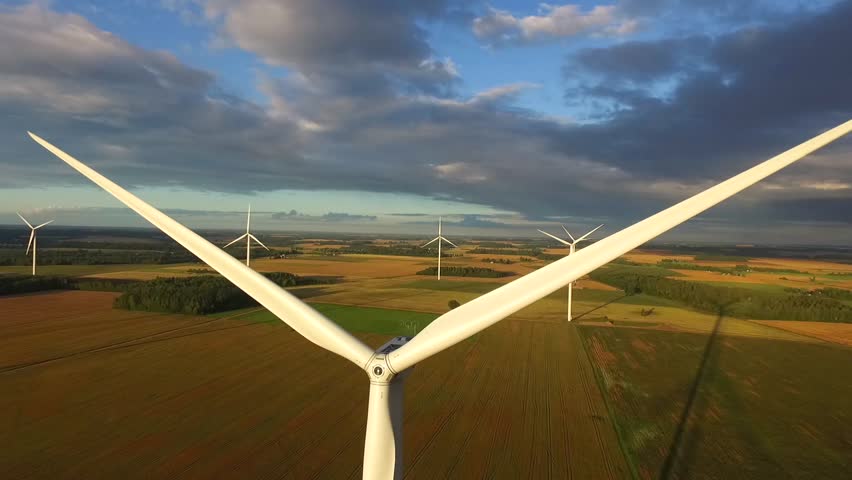 Windmills in Beautiful Nature, Landcape. Sustainable power. Aerial view of wind turbines. Alternative Eco Energy Wind Turbine in Beautiful Green Landscape at Sunset. Aerial drone view