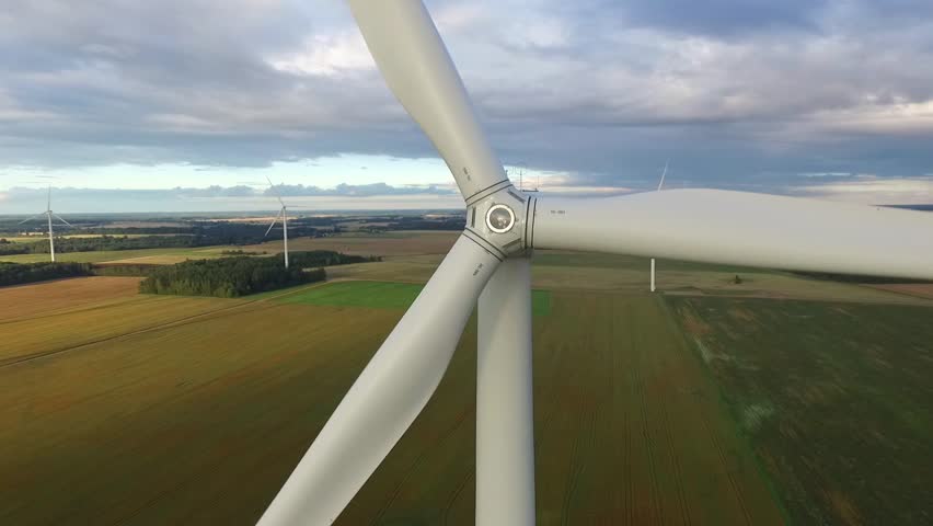 Windmills in Beautiful Nature, Landcape. Sustainable power. Aerial view of wind turbines. Alternative Eco Energy Wind Turbine in Beautiful Green Landscape at Sunset. Aerial drone view