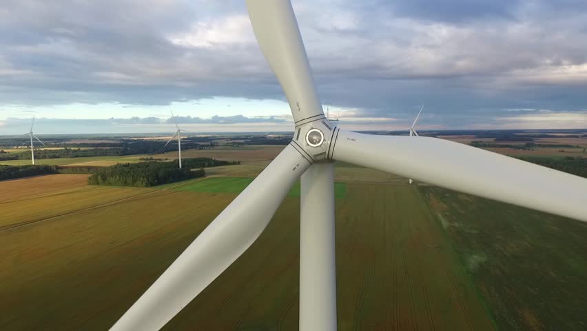 Windmills in Beautiful Nature, Landcape. Sustainable power. Aerial view of wind turbines. Alternative Eco Energy Wind Turbine in Beautiful Green Landscape at Sunset. Aerial drone view