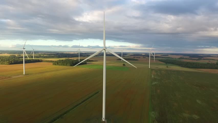 Windmills in Beautiful Nature, Landcape. Sustainable power. Aerial view of wind turbines. Alternative Eco Energy Wind Turbine in Beautiful Green Landscape at Sunset. Aerial drone view