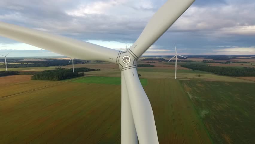 Windmills in Beautiful Nature, Landcape. Sustainable power. Aerial view of wind turbines. Alternative Eco Energy Wind Turbine in Beautiful Green Landscape at Sunset. Aerial drone view