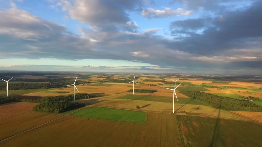 Windmills in Beautiful Nature, Landcape. Sustainable power. Aerial view of wind turbines. Alternative Eco Energy Wind Turbine in Beautiful Green Landscape at Sunset. Aerial drone view