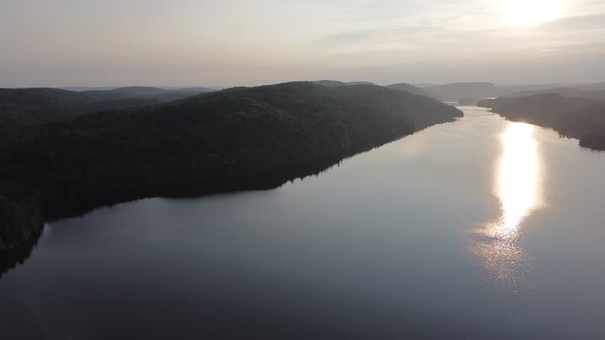 Flight over a lake in the Canadian forest at sunset
