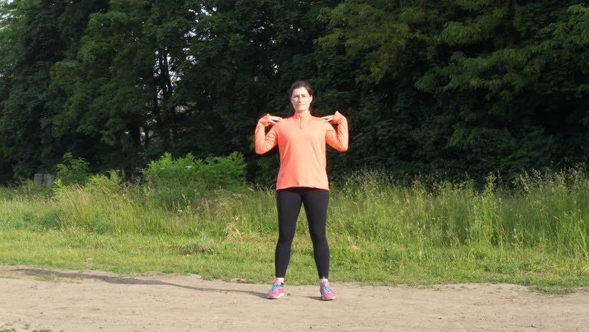 Woman makes exersices in the morning before jogging
