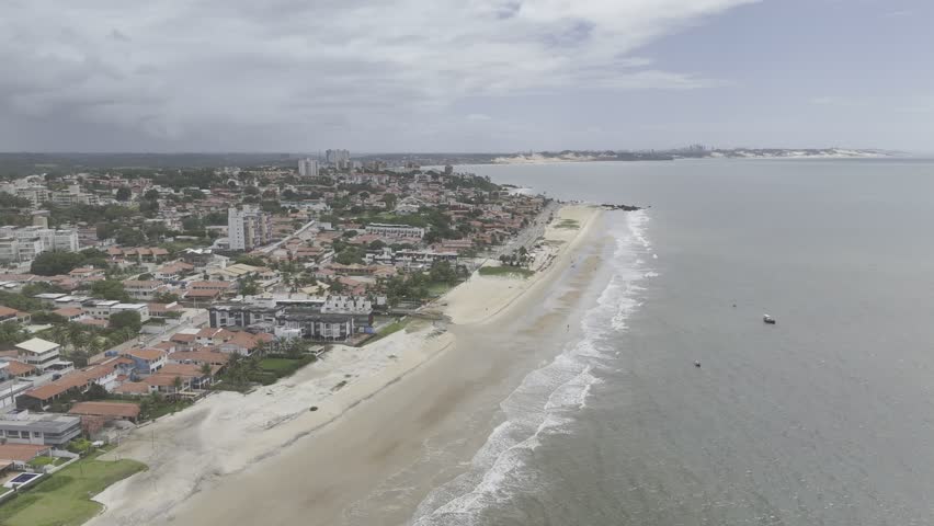 Drone flies backwards along Praia De Pirangi Do Norte in Natal, Rio Grande do Norte, Brazil