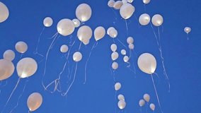 White balloons are set free and they fly high, taken by the wind, with a blue sky background. - Powered by Shutterstock - Get 15% off with code: PIKWIZARD15
