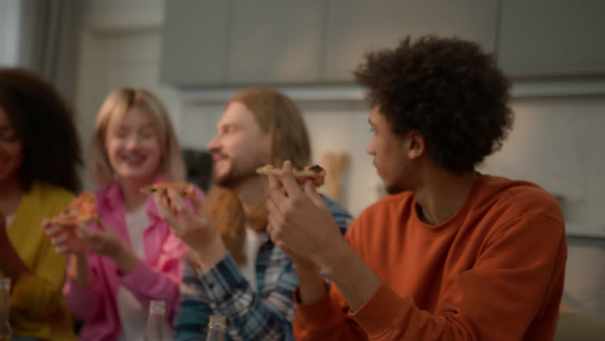 Happy laughing multiracial friends diversity people multiethnic buddies students teenagers African American female women girls Caucasian guys male man eating pizza food delivery together snack tasty