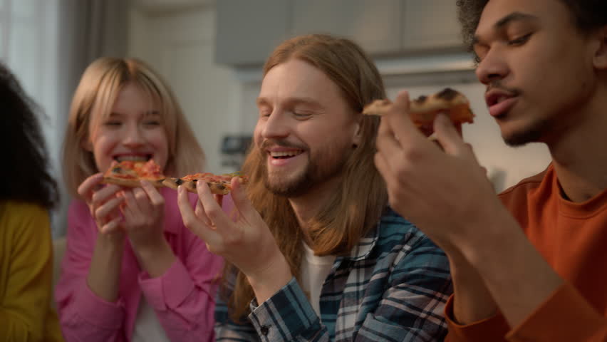 Happy laughing multiracial friends diversity people multiethnic buddies students teenagers African American female women girls Caucasian guys male man eating pizza food delivery together snack tasty