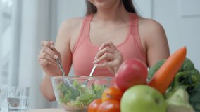 Woman prepares a healthy salad in a modern kitchen, mixing fresh bell peppers and vegetables on the table. Embrace a lifestyle of health and wellness through nutritious meal preparation - Powered by Shutterstock - Get 15% off with code: PIKWIZARD15