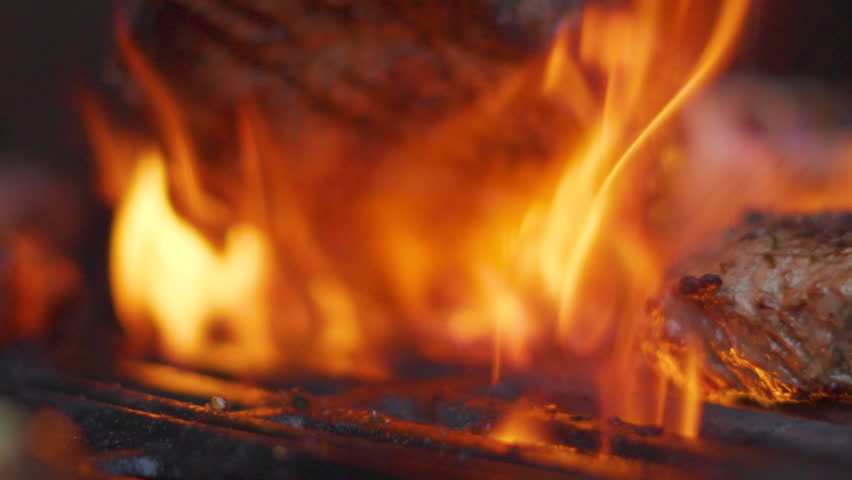 Chef Moving Delicious British Sirloin Steak Out of BBQ Flames Revealing Grilled Meat with Dripping Olive Oil Showing Juicy Tender Superior Quality 4K