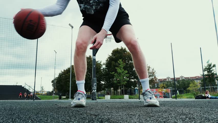 man playing basketball, doing tricks before throwing basketball into basket