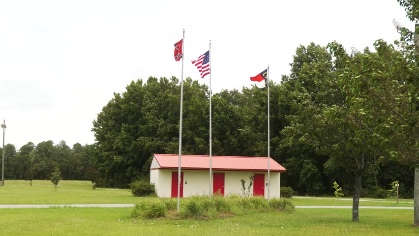 Civil War battle site with the USA, Confederate, and North Carolina state flags blowing in the wind