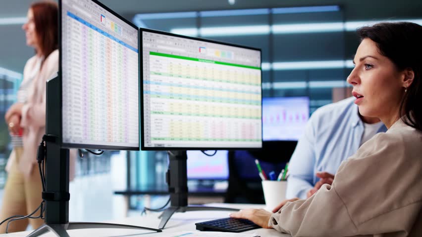 People Working With Spreadsheet Data On Computer Monitor